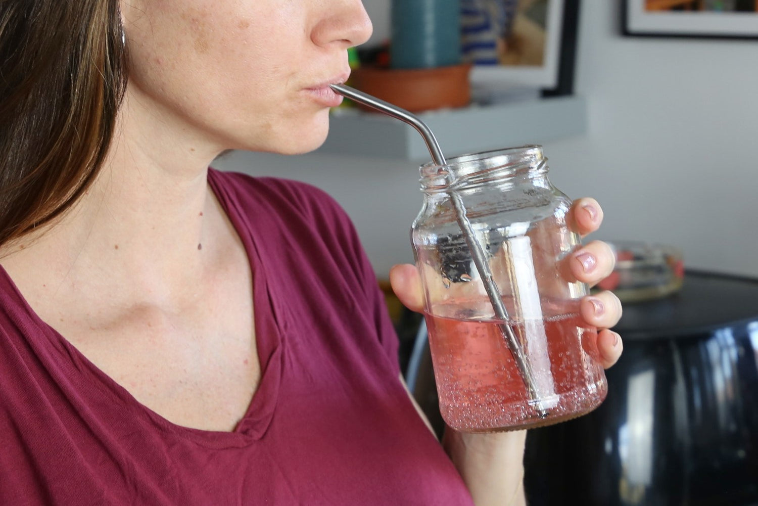 a woman drinking using a Reusable straw made in stainless steel 