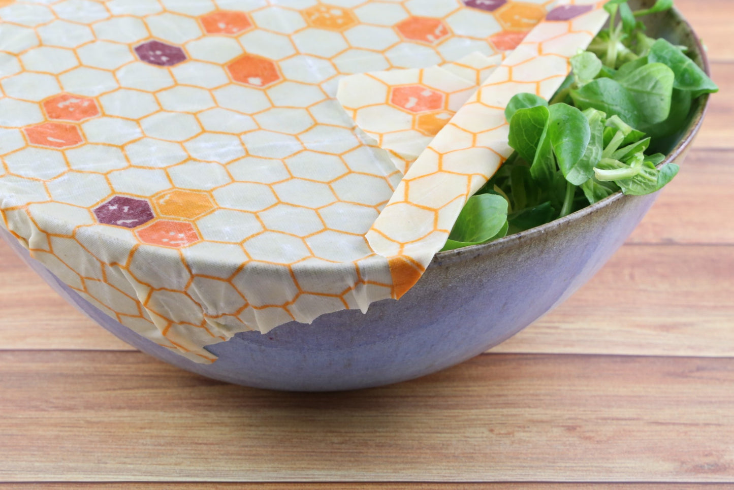 zero waste beeswax food wrap hive pattern from beewise amsterdam being used a food container with salad at the table
