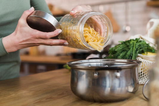 5 Zero-waste kitchen essentials to reduce your environmental impact put food from a glass jar in a pan plastic-free dry goods
