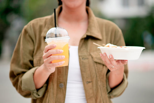 Netherlands: New rule for plastic to-go packaging from July with a woman carrying a plastic cup and a plastic food container