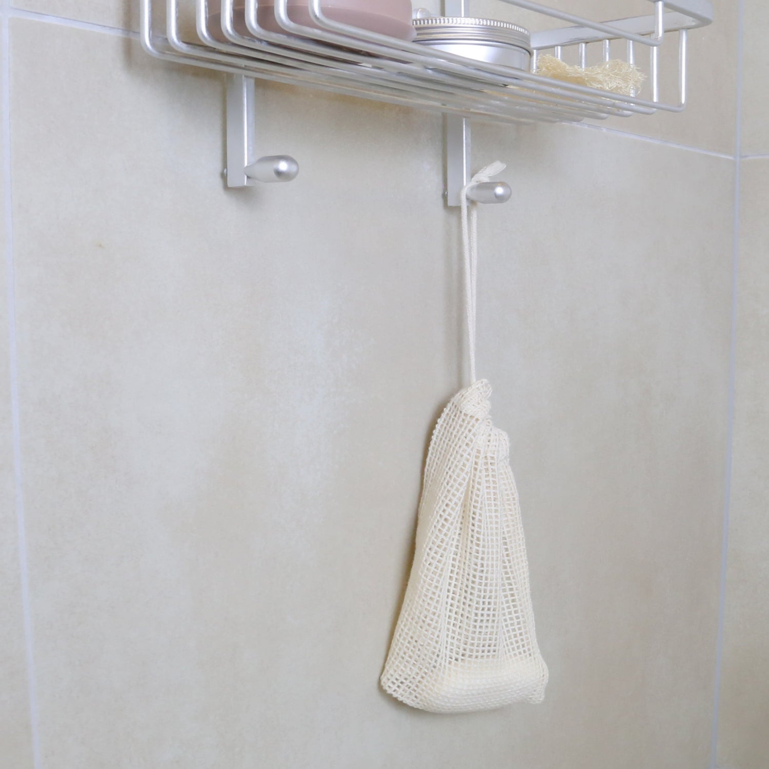 organic cotton mesh bag hanging in the shower with soap inside