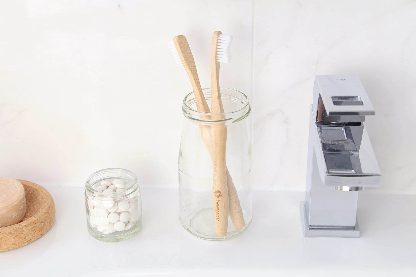 bamboo toothbrush for adults from beewise medium bristles standing on top of a bathroom sink in a glass container