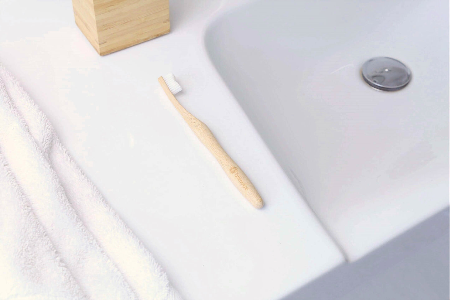 bamboo toothbrush for adults from beewise medium bristles on the top of a bathroom sink