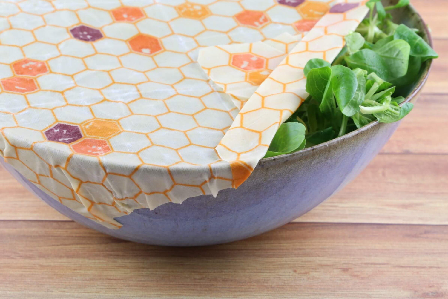 zero waste beeswax food wrap hive pattern from beewise amsterdam being used a food container with salad at the table