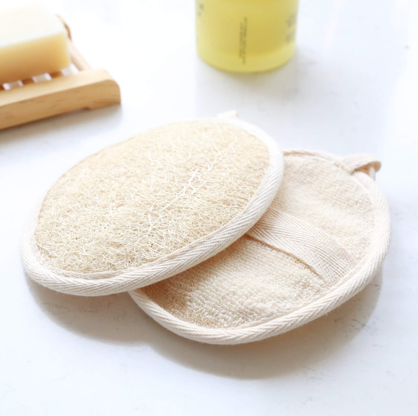 Loofah pad sponge made of natural plant showing front and back on top of a table