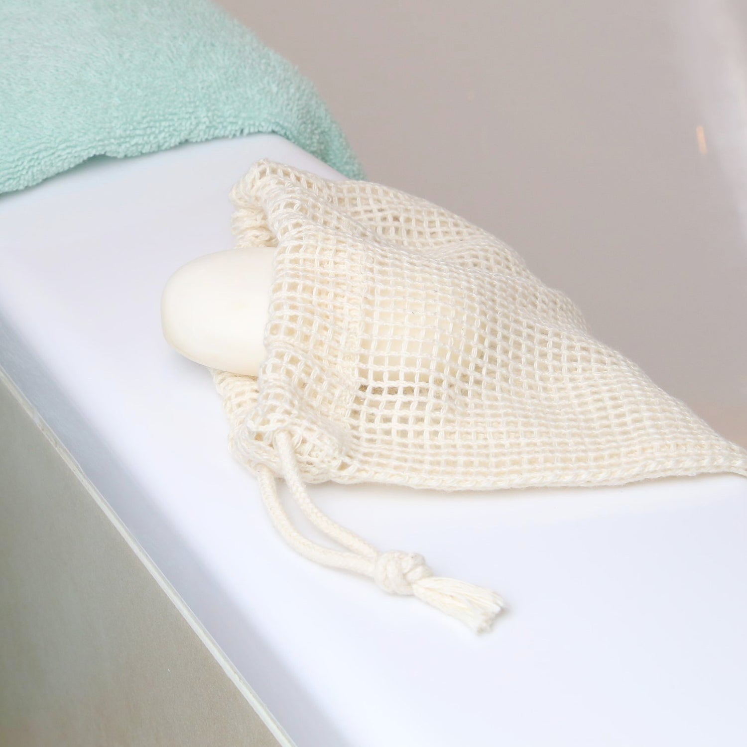 Small organic cotton mesh bag ideal for soap scraps, makeup pads, and socks – perfect for sustainable storage in the bath with a soap inside