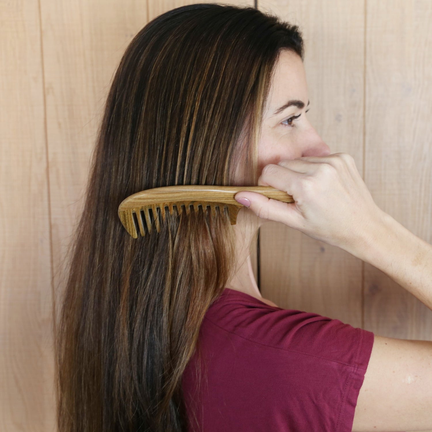 sandalwood comb handmade with a nice design anti static being used by a woman