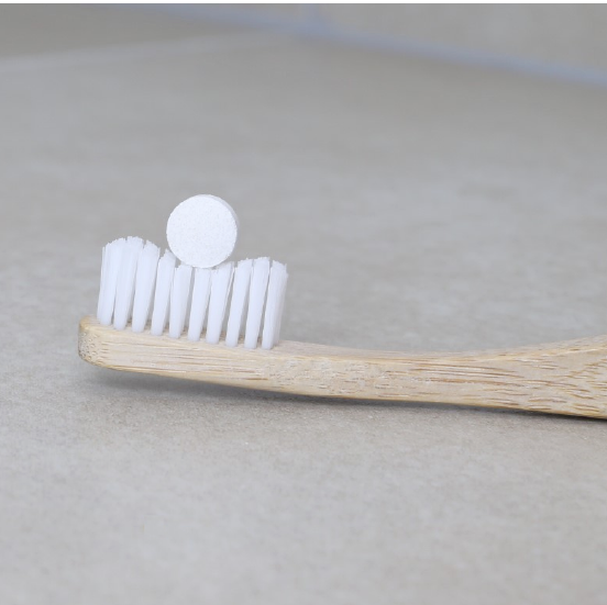 toothpaste tablet in a white bristles bamboo toothbrush