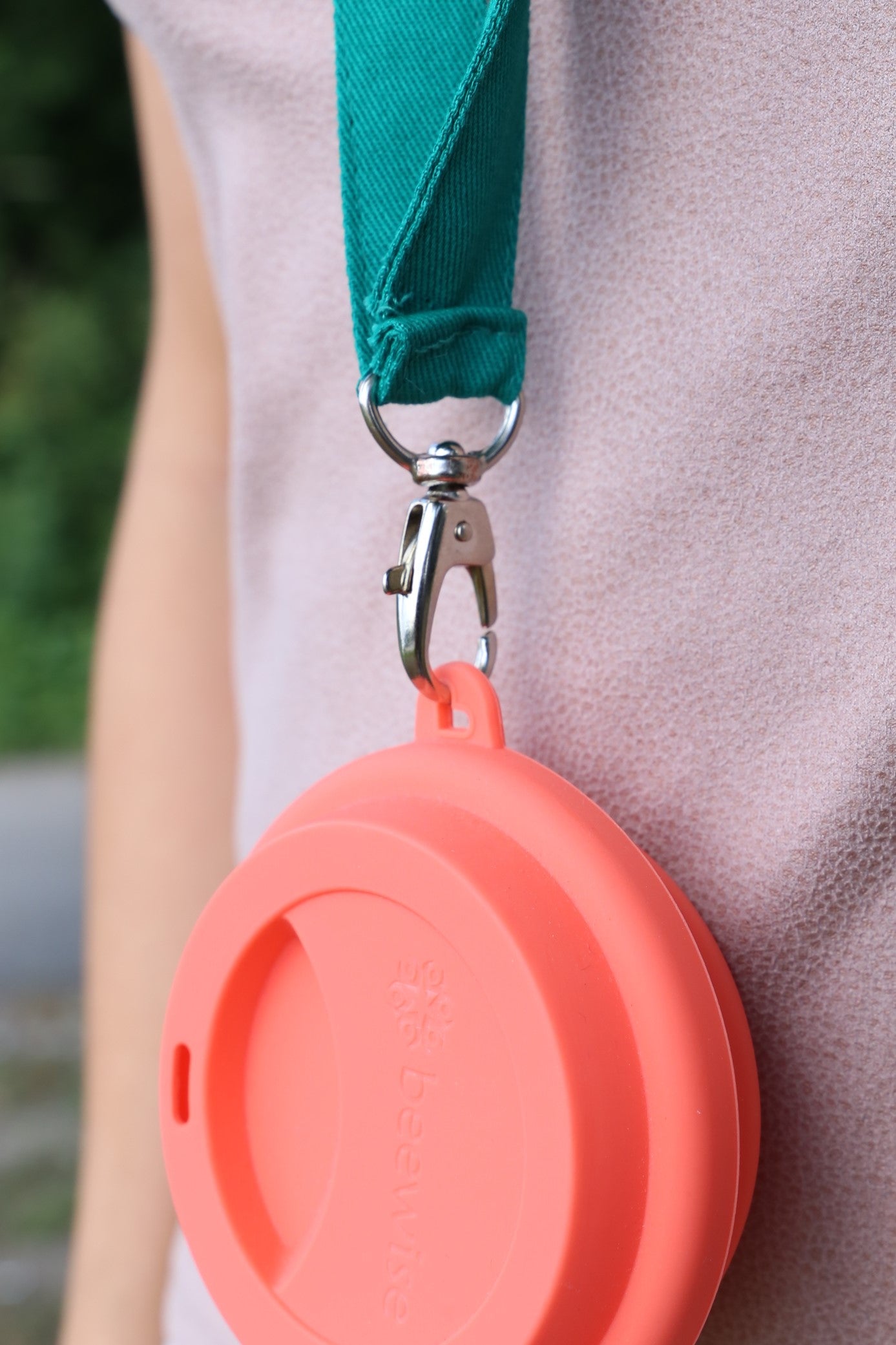 cup holder necklace being showed with a reusable silicone cup on detail