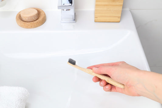 bamboo toothbrushes for adults from Beewise soft charcoal bristles being used in the bathroom sink