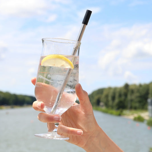 reusable straw collapsible silver case and silver colour with black tip showing in a transparent drink