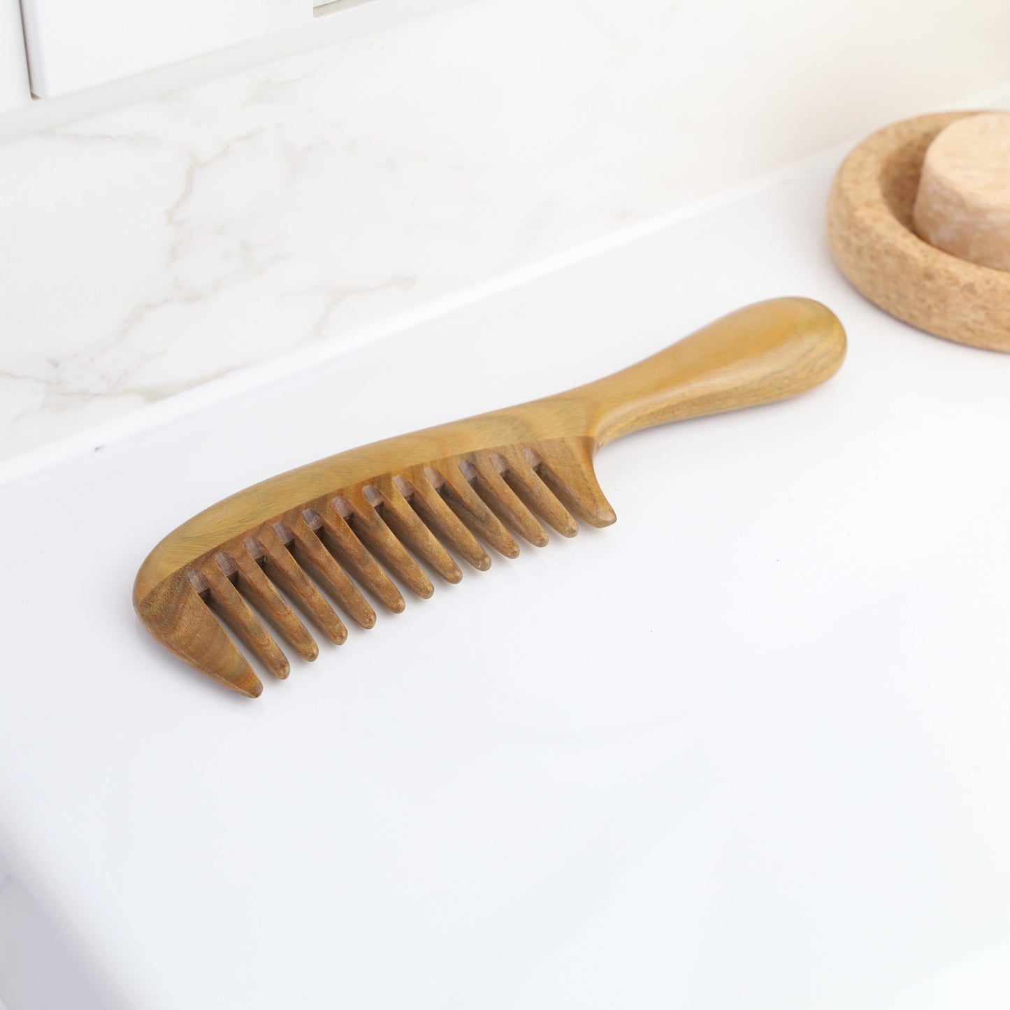 zero-waste and natural sandalwood comb handmade with a nice design anti-static on top of a sink